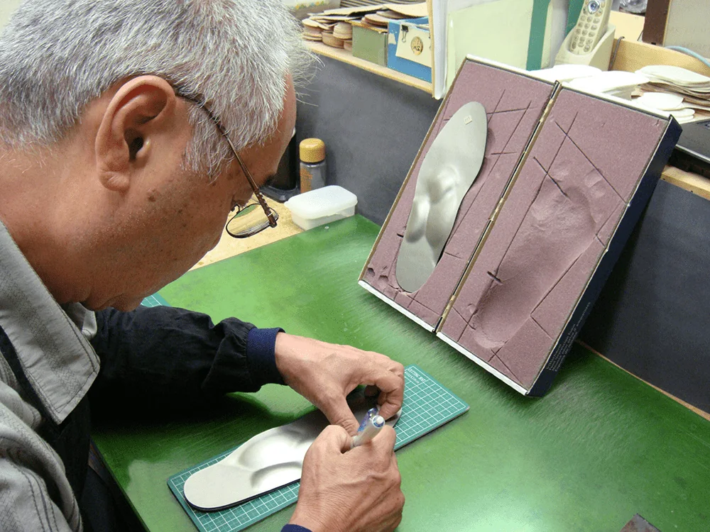 足型を確認しながらスーパーアーチを製作する職人